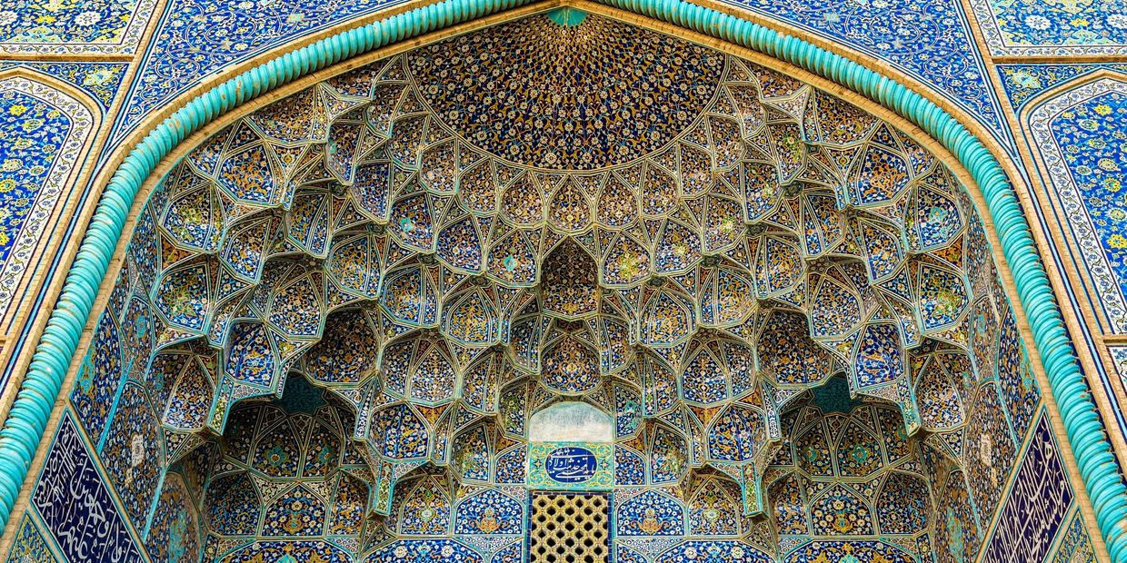 Intricate Islamic geometric patterns adorn a mosque entrance.