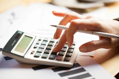 Person using a calculator to analyze financial data.